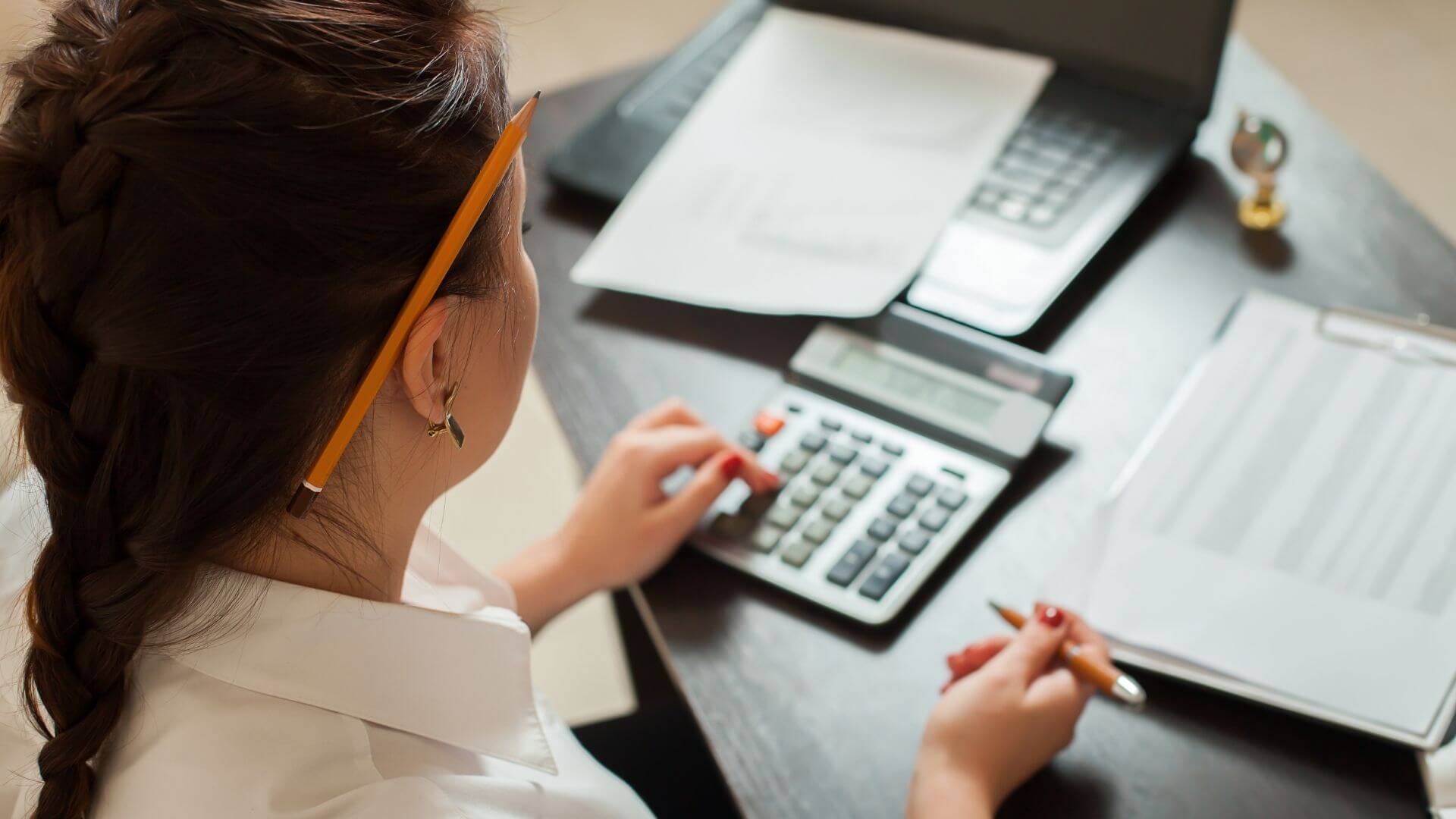 Bookkeeping services in Stockton CA calculating small business finances and reviewing expense reports